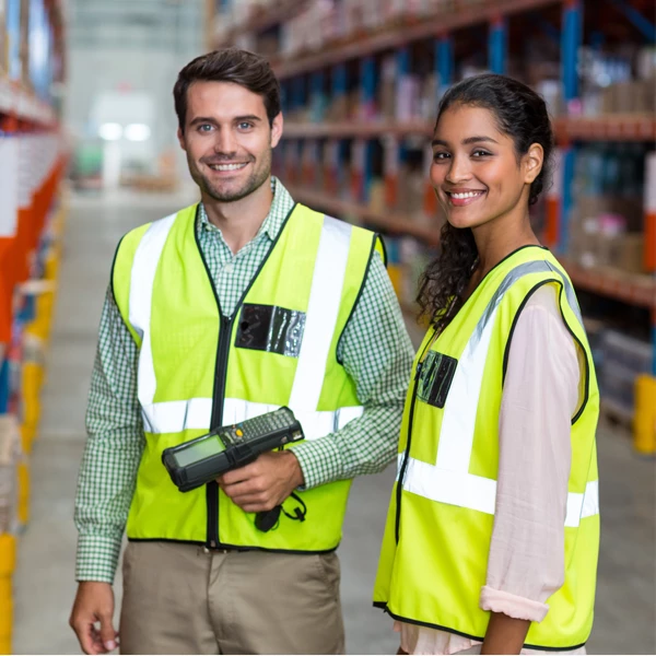 two people in a warehouse wearing safety vests